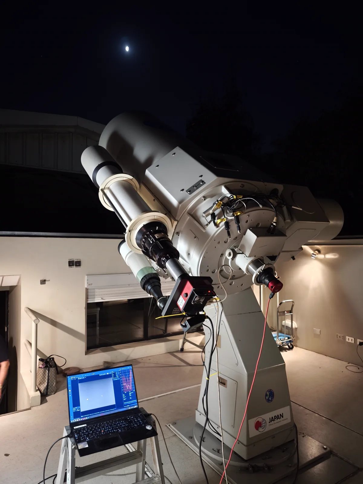 Un telescopio del observatorio, bajo la Luna